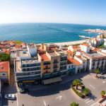 Spanish coastal city with business district and Mediterranean Sea, representing top 10 small business ideas in Spain for foreigners